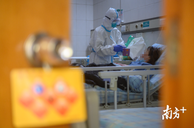 南方医院隔离病房内，一位护士正喂一位患者喝水。 南方日报记者 张梓望 李细华 摄